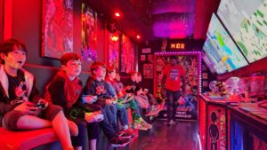 Inside view of All Out Gaming Experience's mobile game truck with multiple gaming stations and LED lighting.